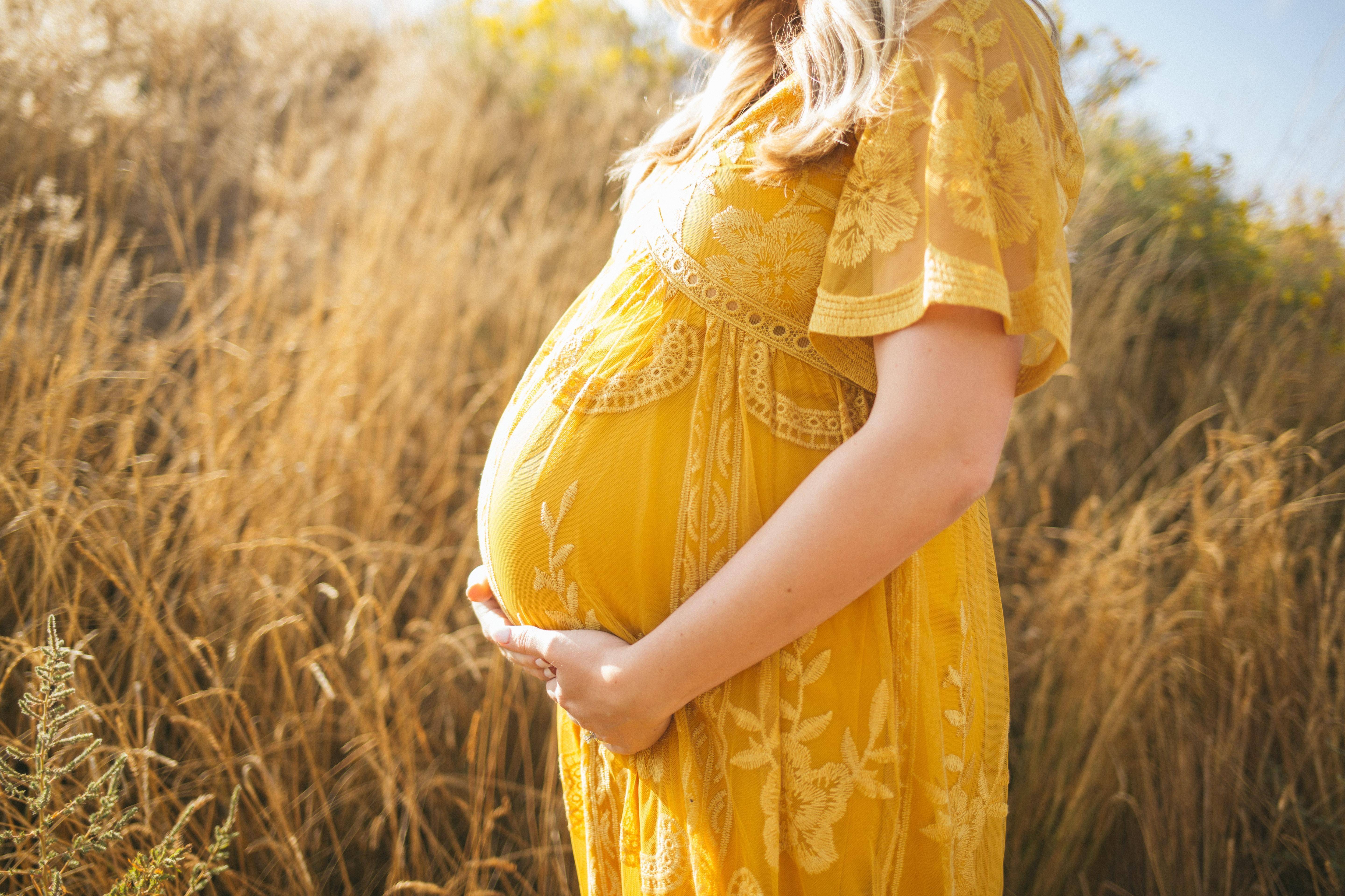 Pregnant surrogate holding her belly